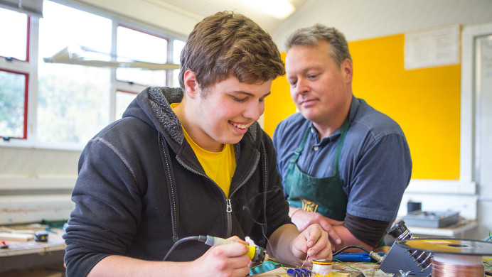 An NCEA teacher show a student how to do a practical experiment