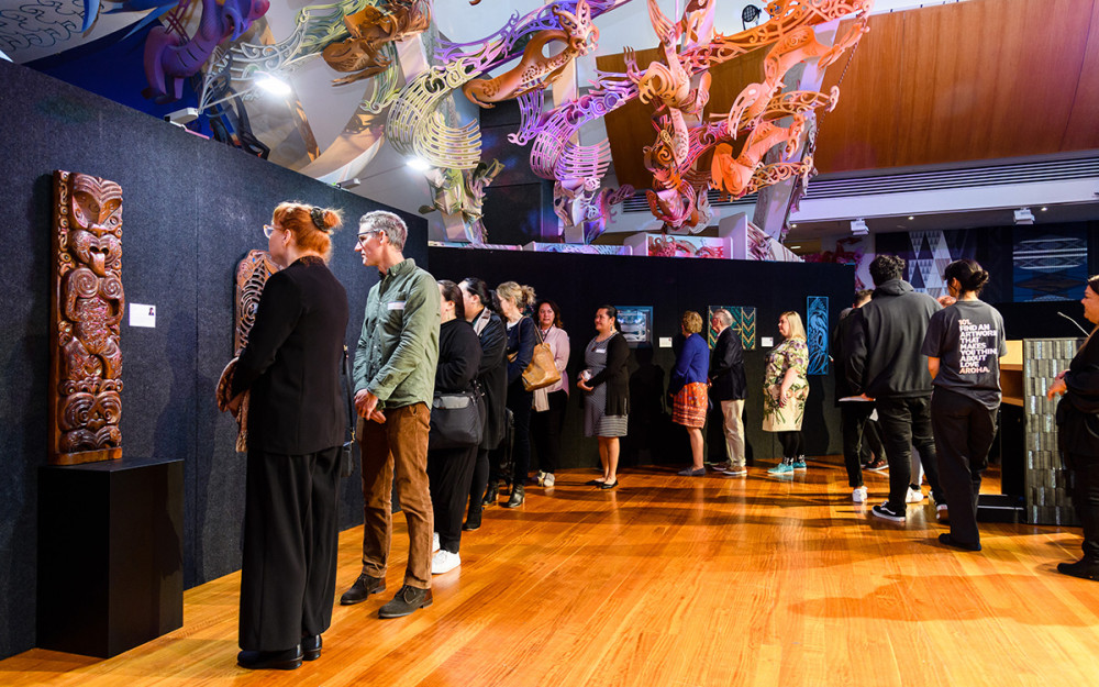 People looking at the artworks in the Ringa Toi exhibition.