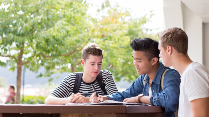 Students sit outside studying