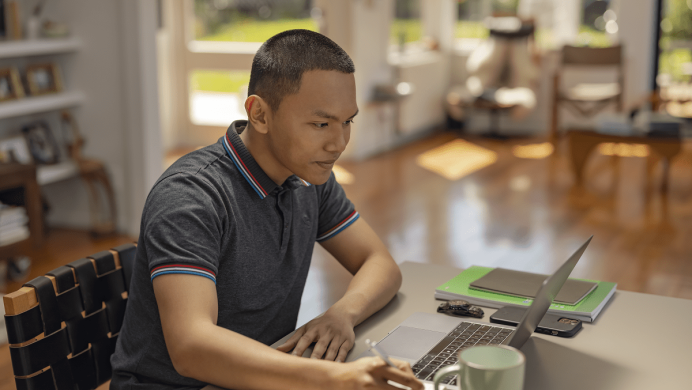 Man taking notes looking at computer