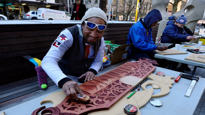 Man using a traditional Māori carving style