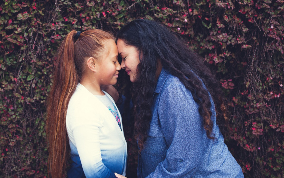 A woman and girl do a hongi