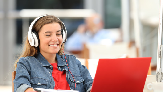 A teenager is watching a video on her laptop