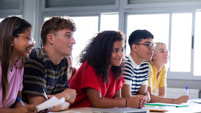 High school students sit at a shared desk in a classroom