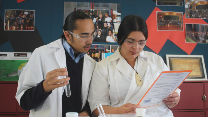 Students conduct a science experiment in a school room.
