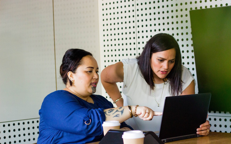 An auditor points out information on her computer.
