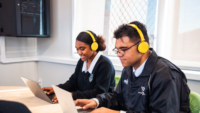 Two Pasifika students take an exam online.