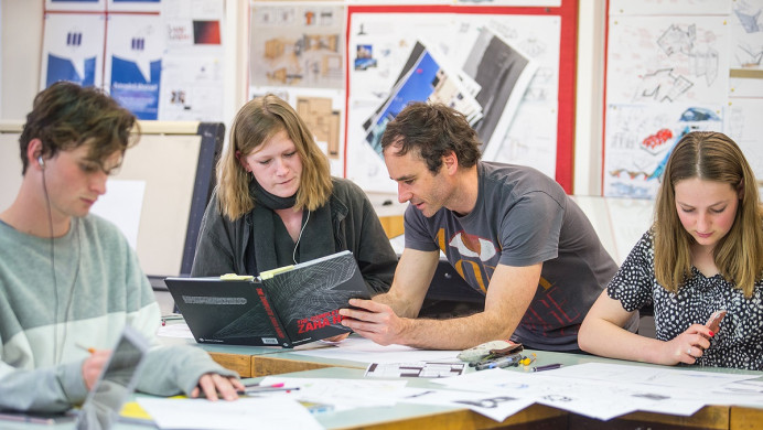 Teacher supports students with lesson
