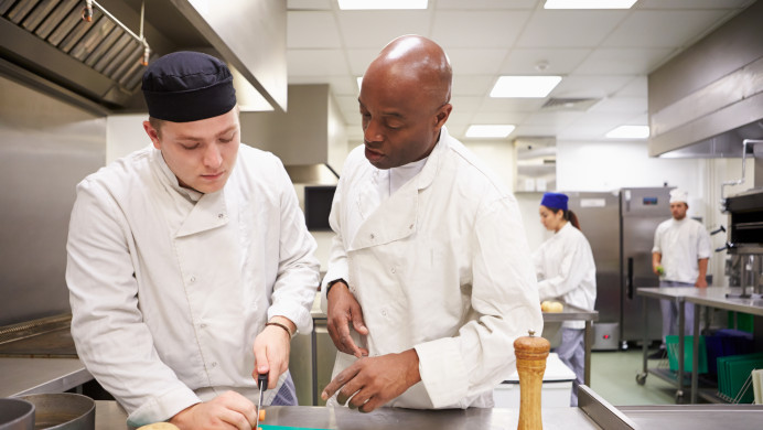 Apprentice chef and tutor in kitchen