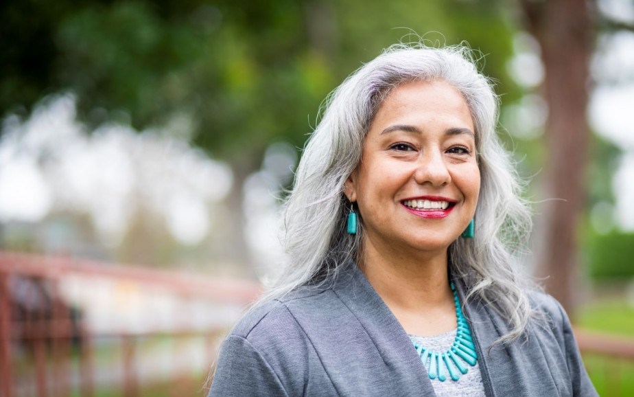 An older administrator smiles at the camera