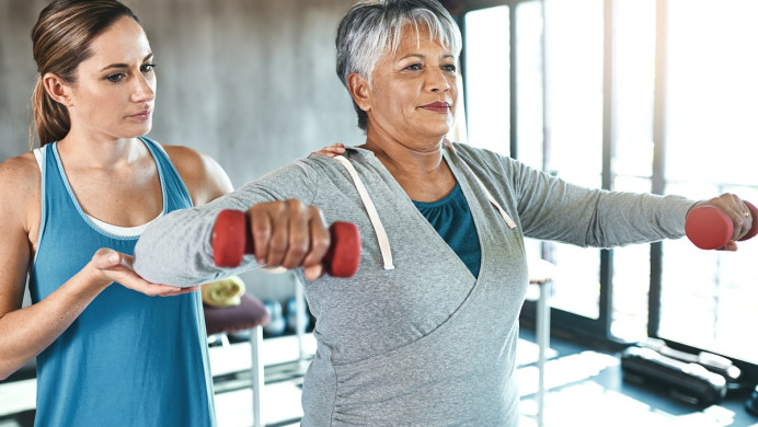 Physiotherapist helps client with strength
