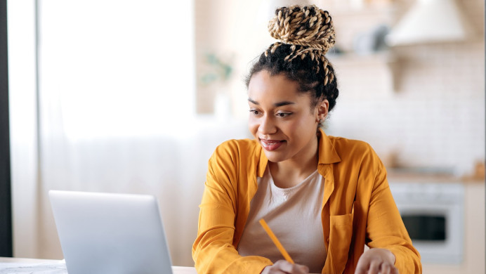 Woman takes notes from laptop